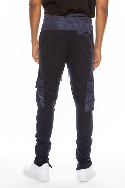 Person wearing dark blue pants with reflective accents on a white background