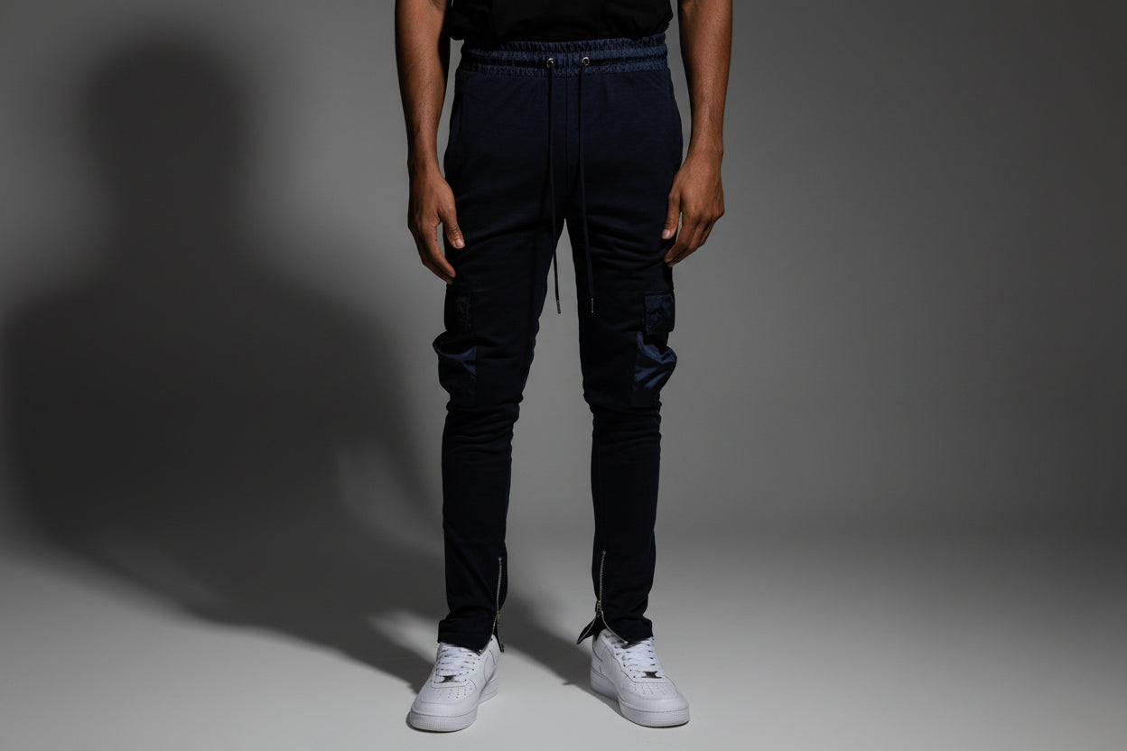 Man wearin joggers that zip in studio with dark background