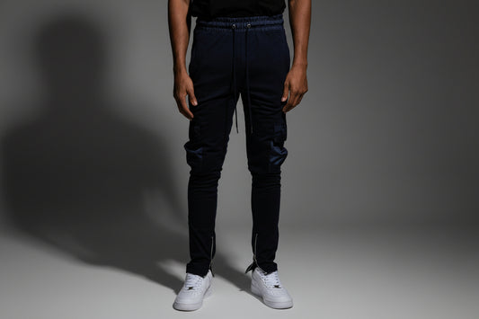 Man wearin joggers that zip in studio with dark background